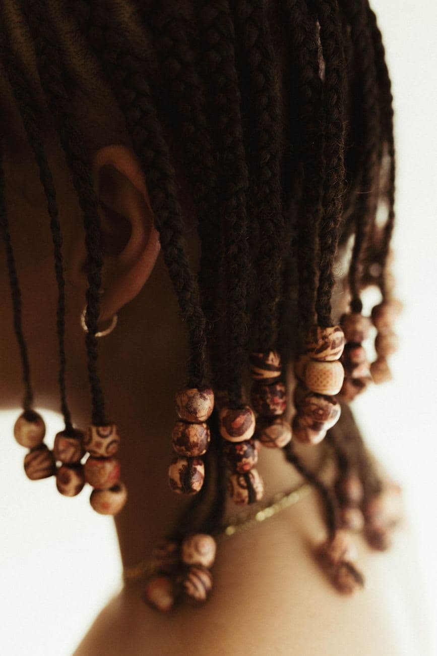 Artistic close-up of African hair braids adorned with decorative wooden beads.