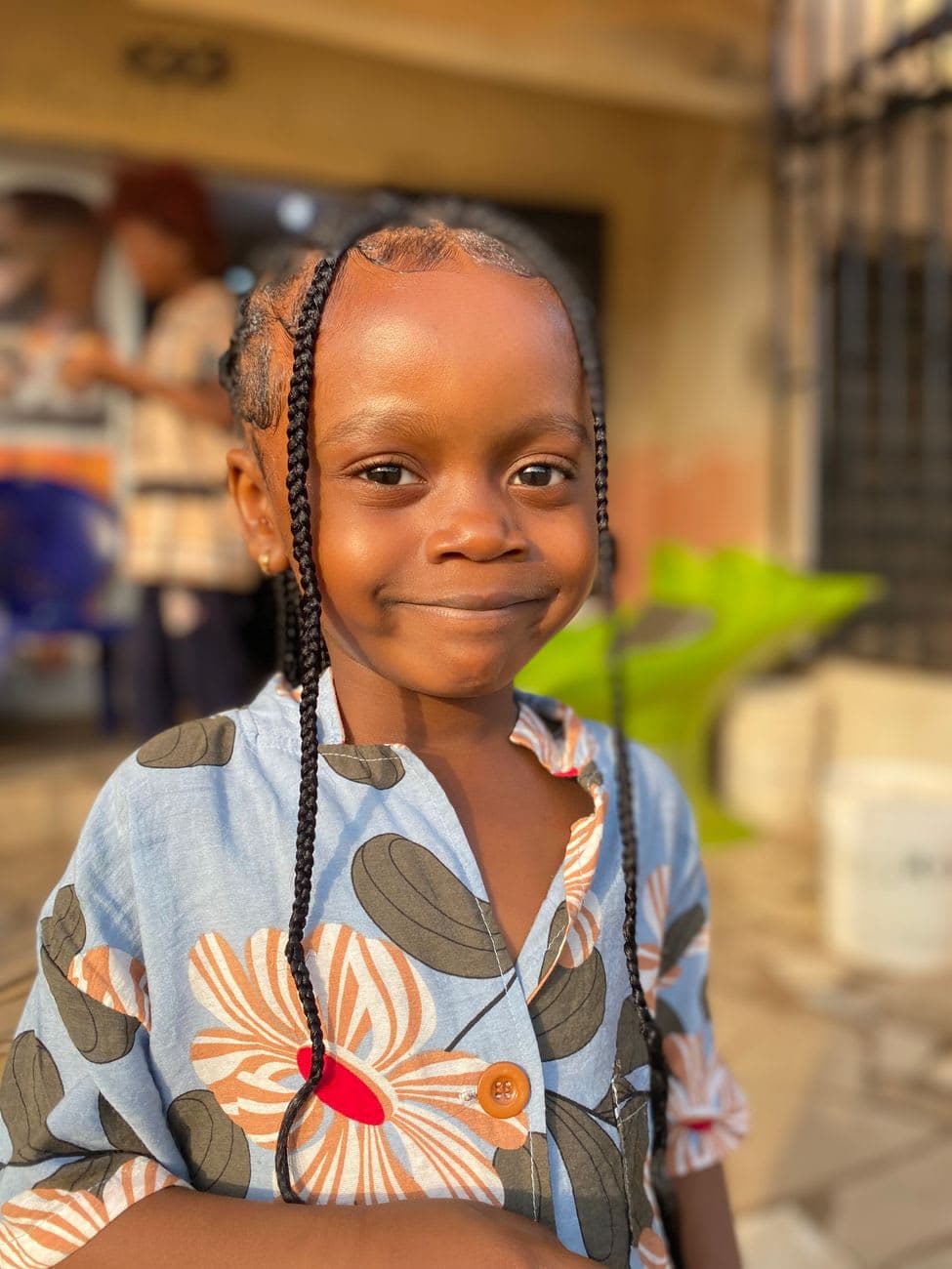 Delightful portrait of a cheerful young girl with braided hair outdoors.