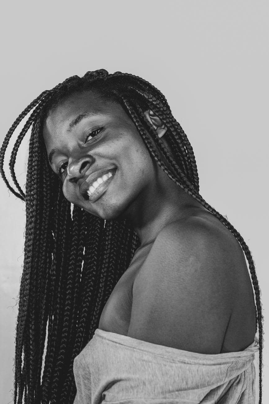 Elegant black and white portrait of a smiling woman with long braided hair.