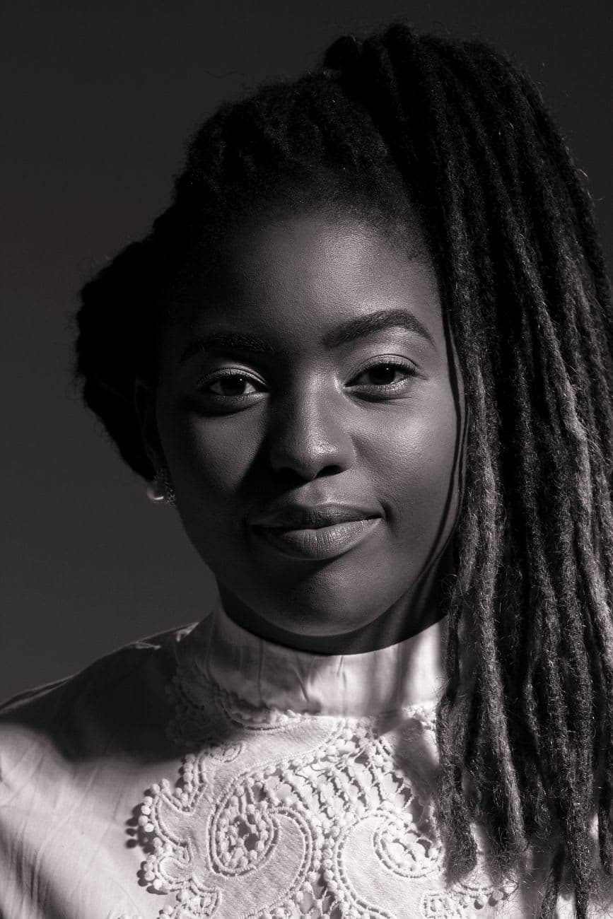 Elegant black and white portrait of a woman with dreadlocks and a serene expression.