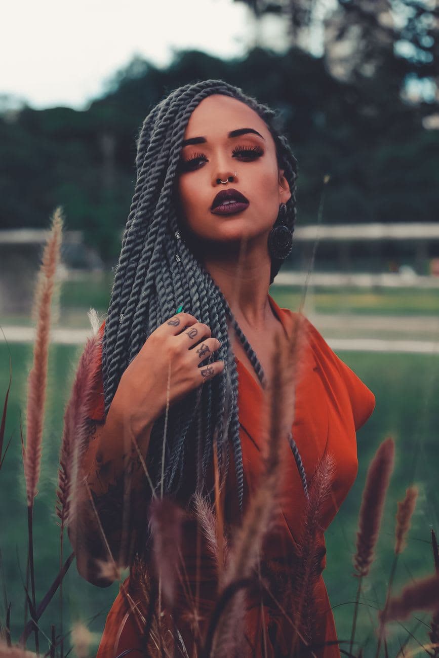 Beautiful portrait of a woman with braids standing confidently outdoors.