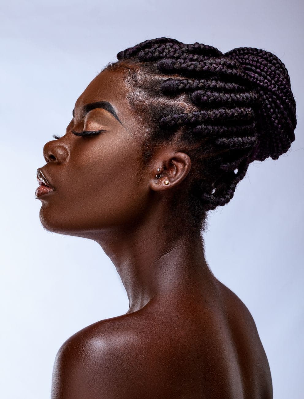 Close-up profile portrait of a woman with braided hair.